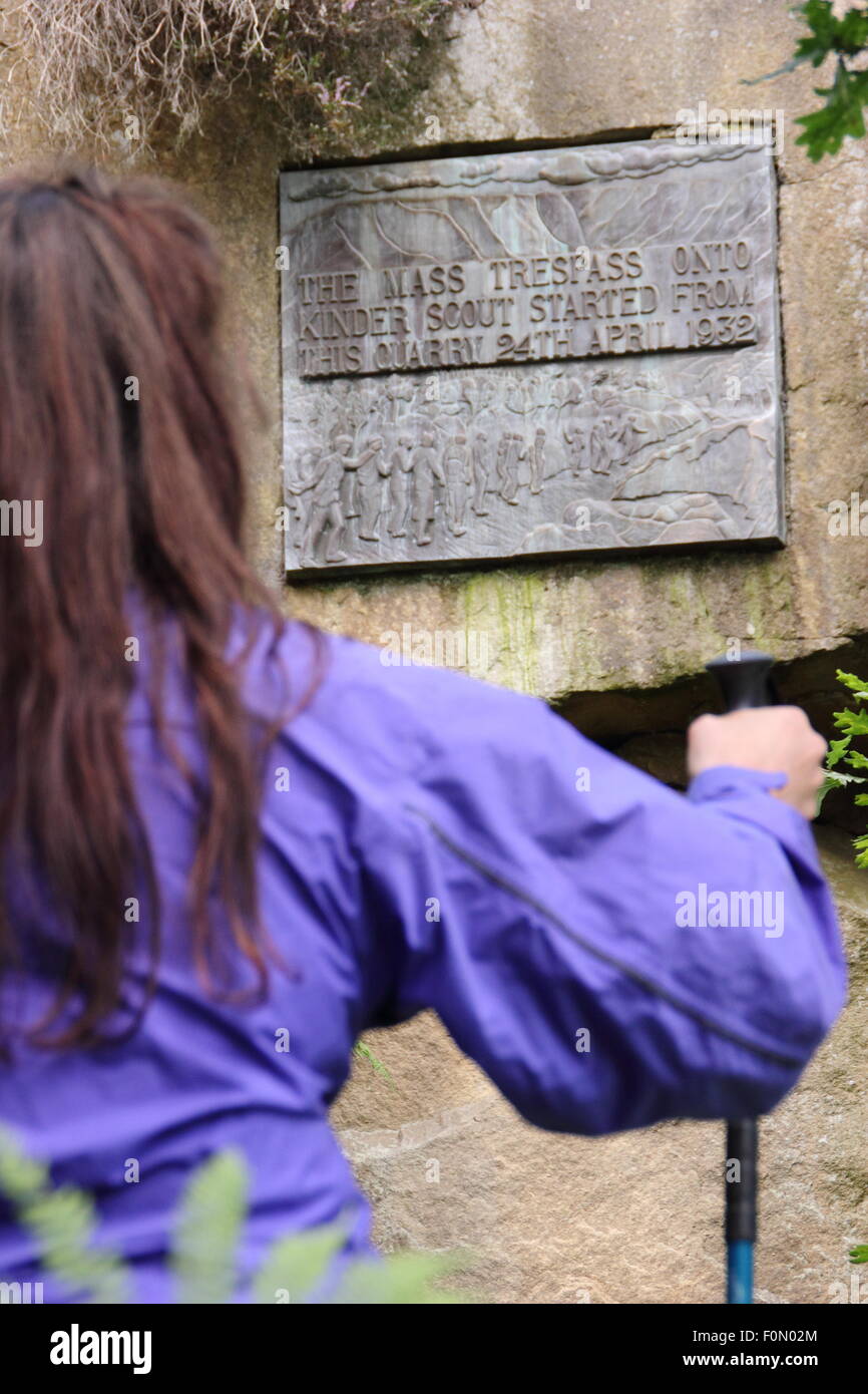 Une femelle walker inspecte la plaque dans la carrière de pont sous gaine qui commémore le sacrifice de masse de Kinder Scout, Derbyshire, Royaume-Uni Banque D'Images