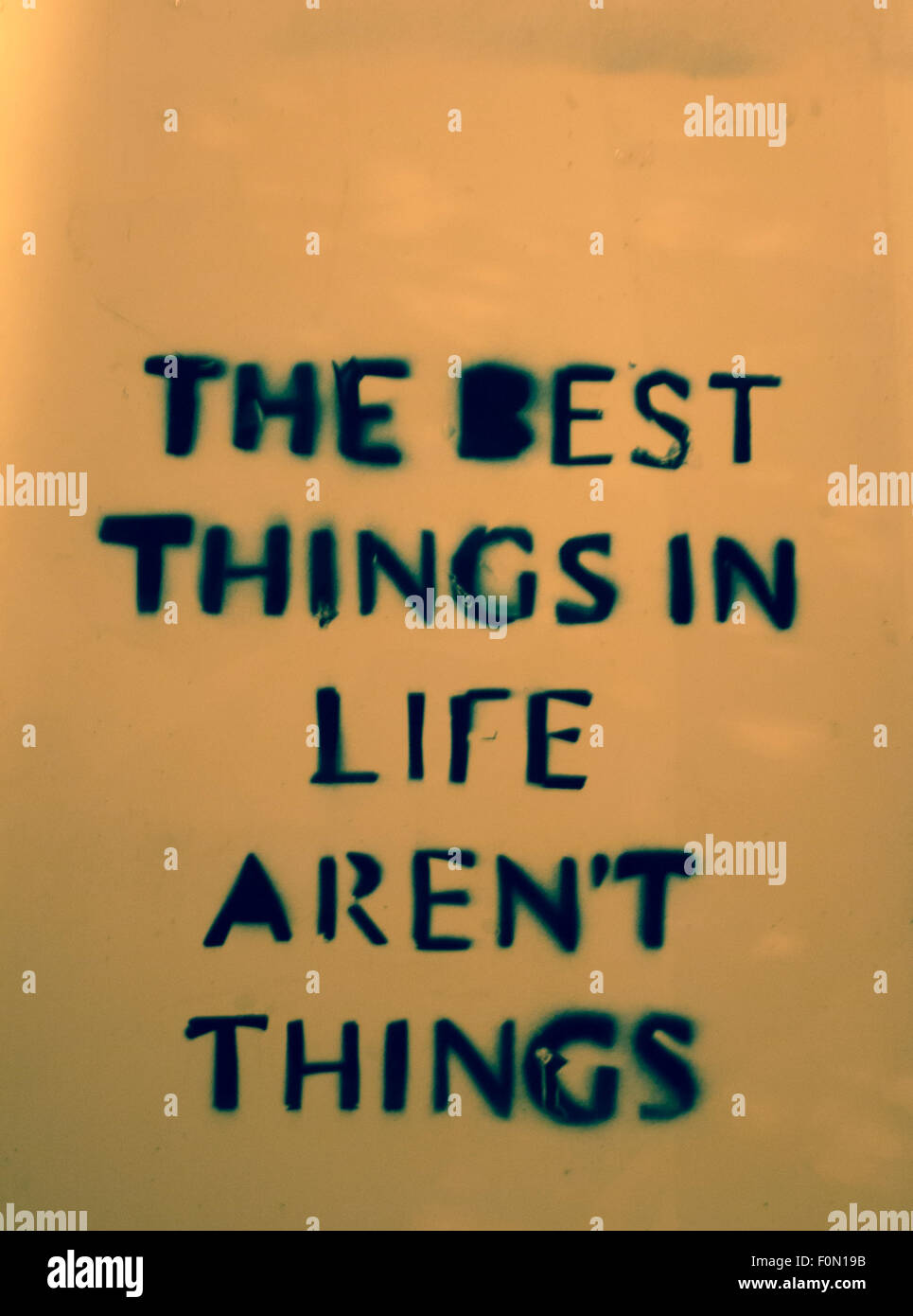 Message urbain disant les meilleures choses dans la vie ne sont pas des choses écrites sur un mur à Bruxelles, photo prise la nuit Banque D'Images