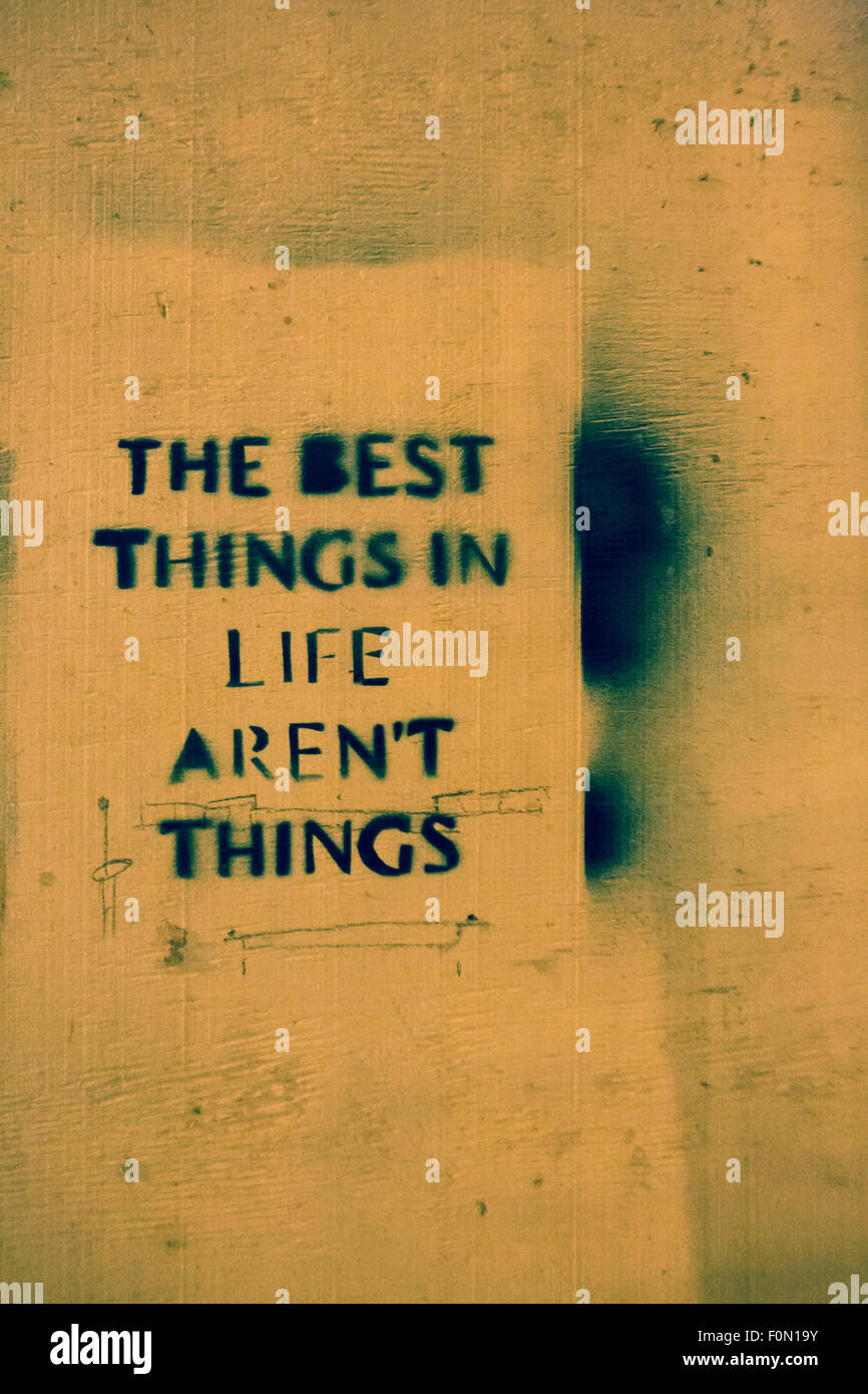 Message urbain disant les meilleures choses dans la vie ne sont pas des choses écrites sur un mur à Bruxelles, photo prise la nuit Banque D'Images