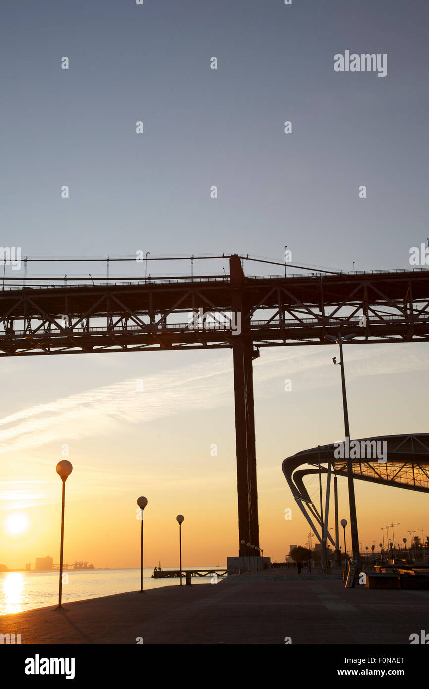 Suspension Bridge avec coucher du soleil sur la mer. Le Pont 25 de Abril est un pont suspendu reliant la ville de Lisbonne Banque D'Images