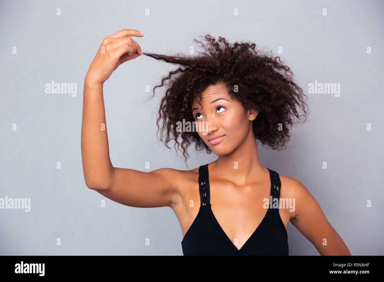 Portrait femme de toucher ses cheveux sur fond gris Banque D'Images