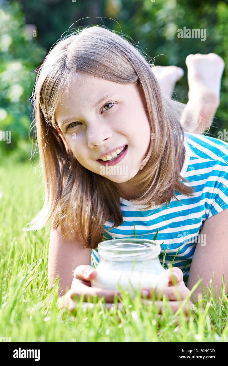 Fille avec un pichet de lait à sunny meadow Banque D'Images