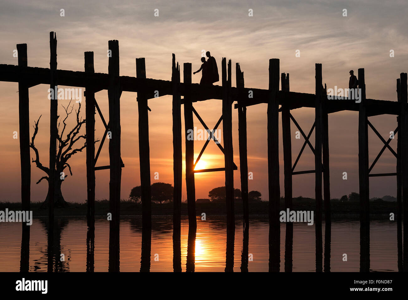 Deux moines marcher sur le pont U Bein, le lac Taungthaman, rétro-éclairage, lumière du soir, coucher de soleil, Amarapurna, Mandalay Division Banque D'Images