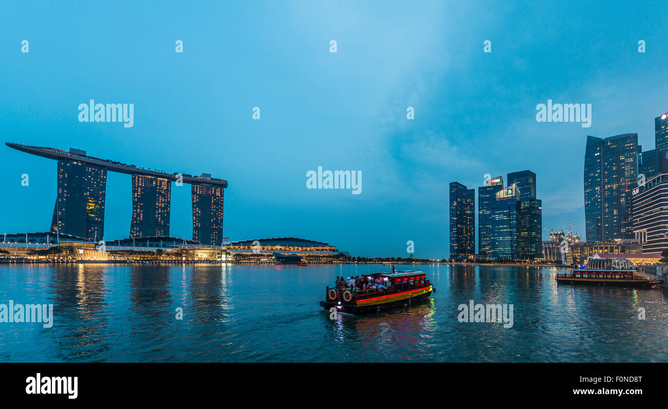 Bateau sur le fleuve de Singapour, au crépuscule, Marina Bay Sands Hotel et quartier des finances derrière, crépuscule, Marina Bay, Singapour Banque D'Images