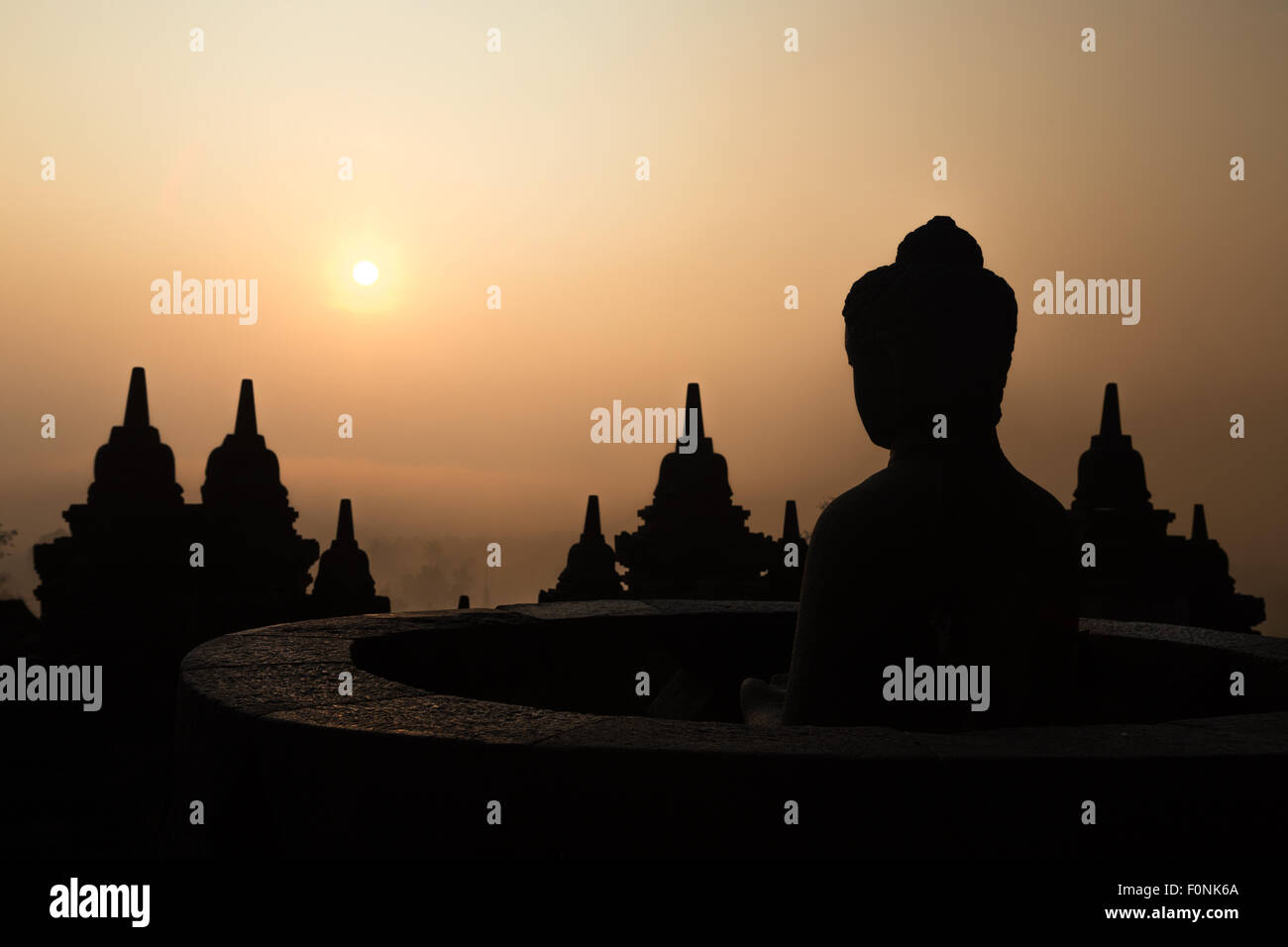 Silhouettes d'une statue de Bouddha au site du patrimoine mondial de l'Unesco le Borobudur temple à l'aube sur l'île de Java, en Indonésie, en Asie. Banque D'Images