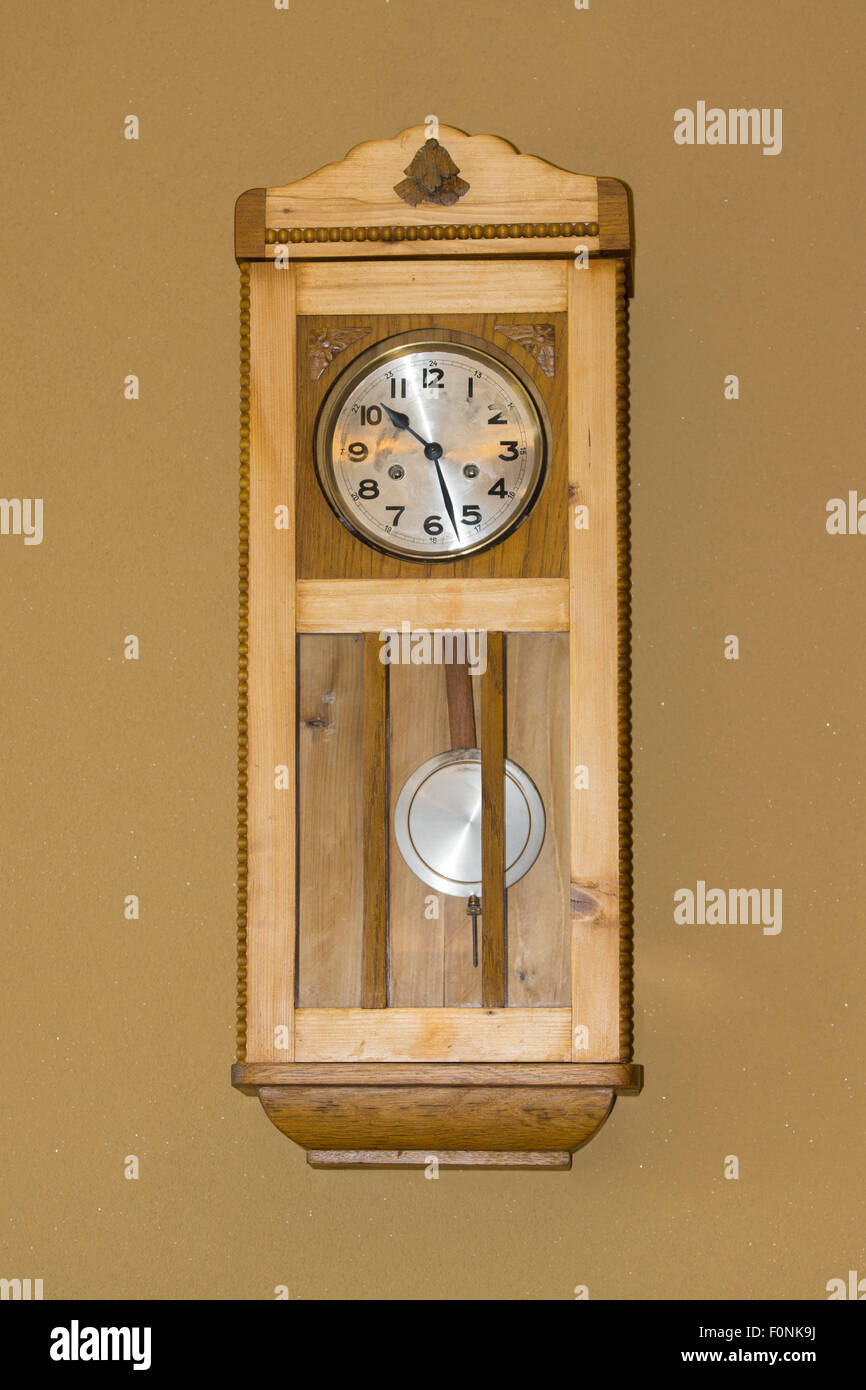 Une horloge en bois de style traditionnel montée au mur intérieur avec pendule et un visage avec des chiffres sur une maison en Autriche. Concept : temps, temps perdu Banque D'Images