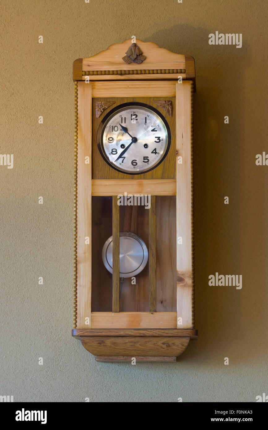 Une horloge en bois de style traditionnel à montage mural intérieur avec pendule et un visage avec des chiffres dans une maison en Autriche. Concept : temps Banque D'Images