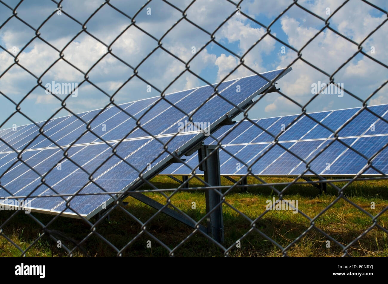 Panneau solaire clôturé dans un fil rouillé dans un champ Banque D'Images