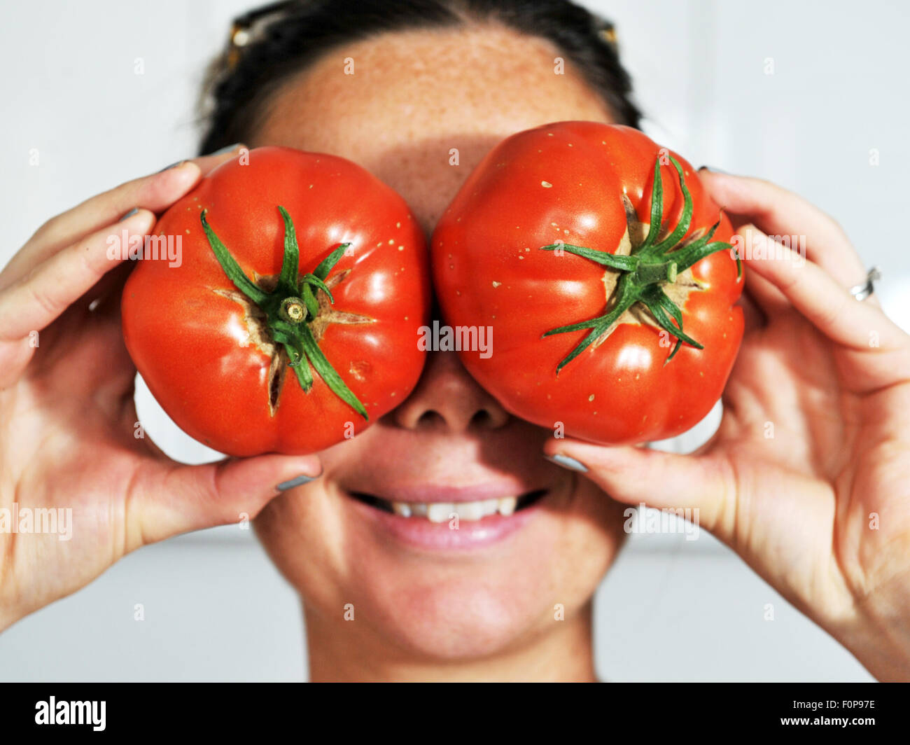 Jeune femme avec de grands yeux rouges tomates comme drôle photos de