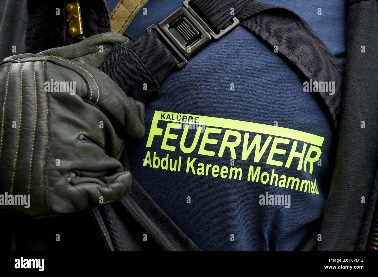 Kaluebbe, Allemagne. Août 19, 2015. Les réfugiés syriens Abdul Kareem Mohammad présente son t-shirt "Feuerwehr" (lit. d'incendie) au cours d'un exercice physique en Kaluebbe, Allemagne, 19 août 2015. L'homme se prépare à la formation de pompier à travailler comme volontaire dans le service d'incendie dans la municipalité. Photo : Carsten REHDER/dpa/Alamy Live News Banque D'Images