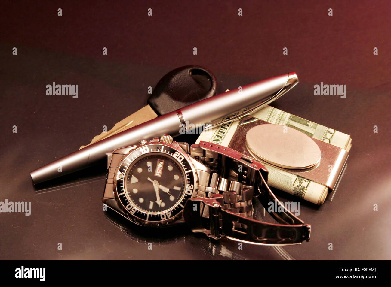 Clé de voiture avec un stylo montre-bracelet et de l'argent comptant dans un clip Banque D'Images