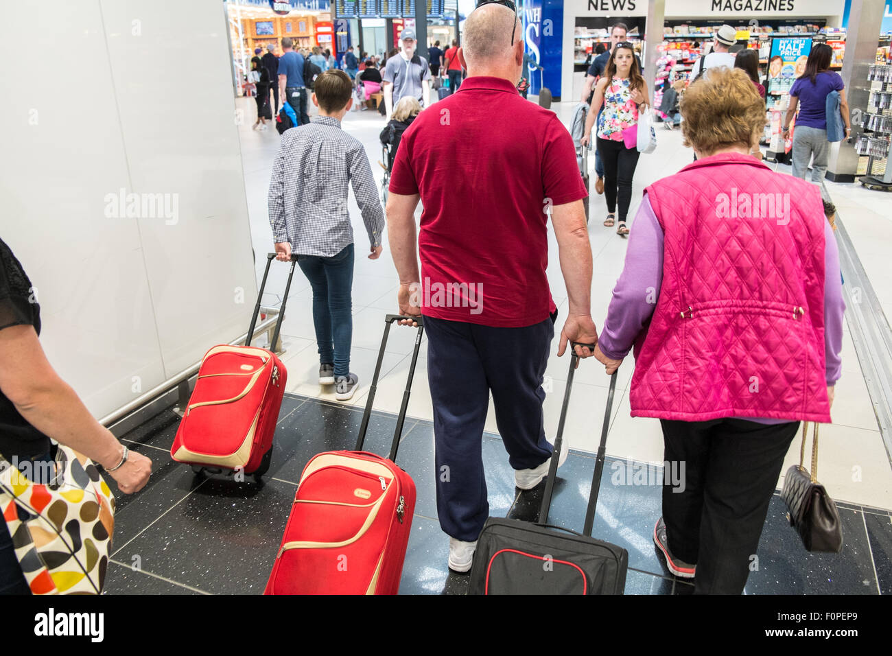 Les passagers, les gens du voyage avec une assurance et des boutiques, change de terminal des départs à l'aéroport de Stansted, Royaume-Uni,Londres Banque D'Images