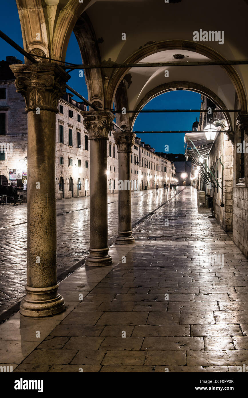 Croatie Dubrovnik la place de la vieille ville de Stradun montrant des arches et piliers allumé avec des lanternes dans la nuit Banque D'Images
