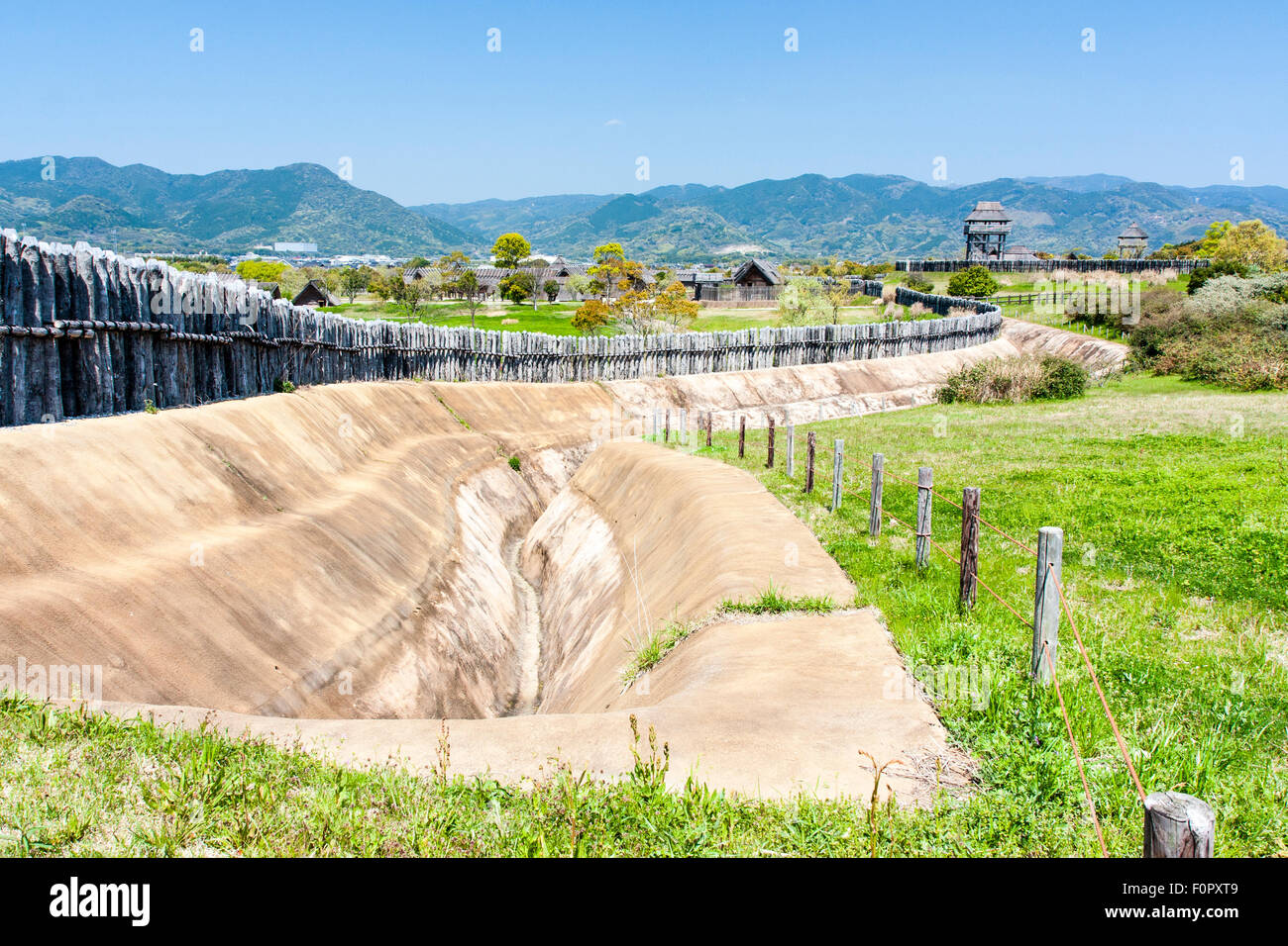 Le Japon, l'âge du fer Yoshinogari Parc historique. Yayoi reconstruit pièce jointe. L'pieu de bois mur défensif avec fossé et tours de garde. Banque D'Images