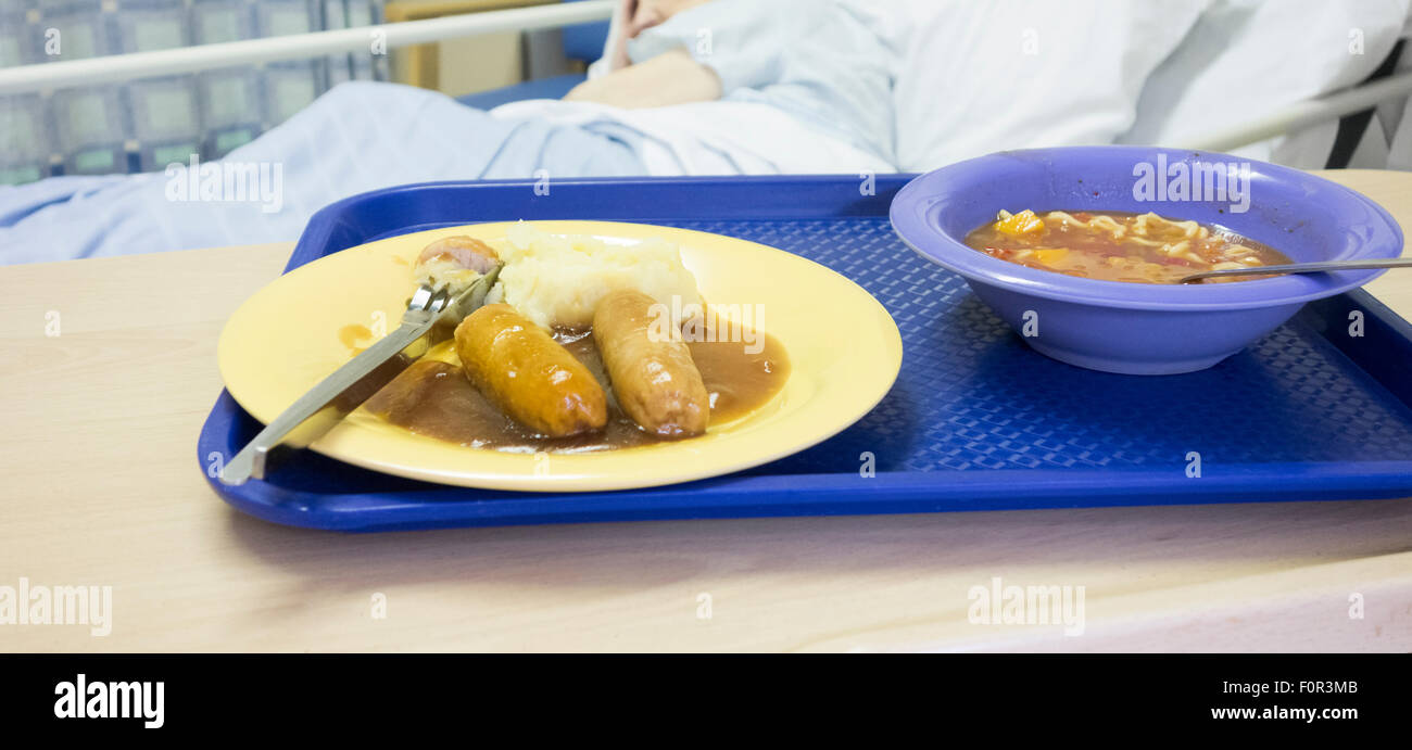 Quatre-vingt-dix ans vieille dame au lit d'hôpital hôpital NHS avec repas sur table. Banque D'Images