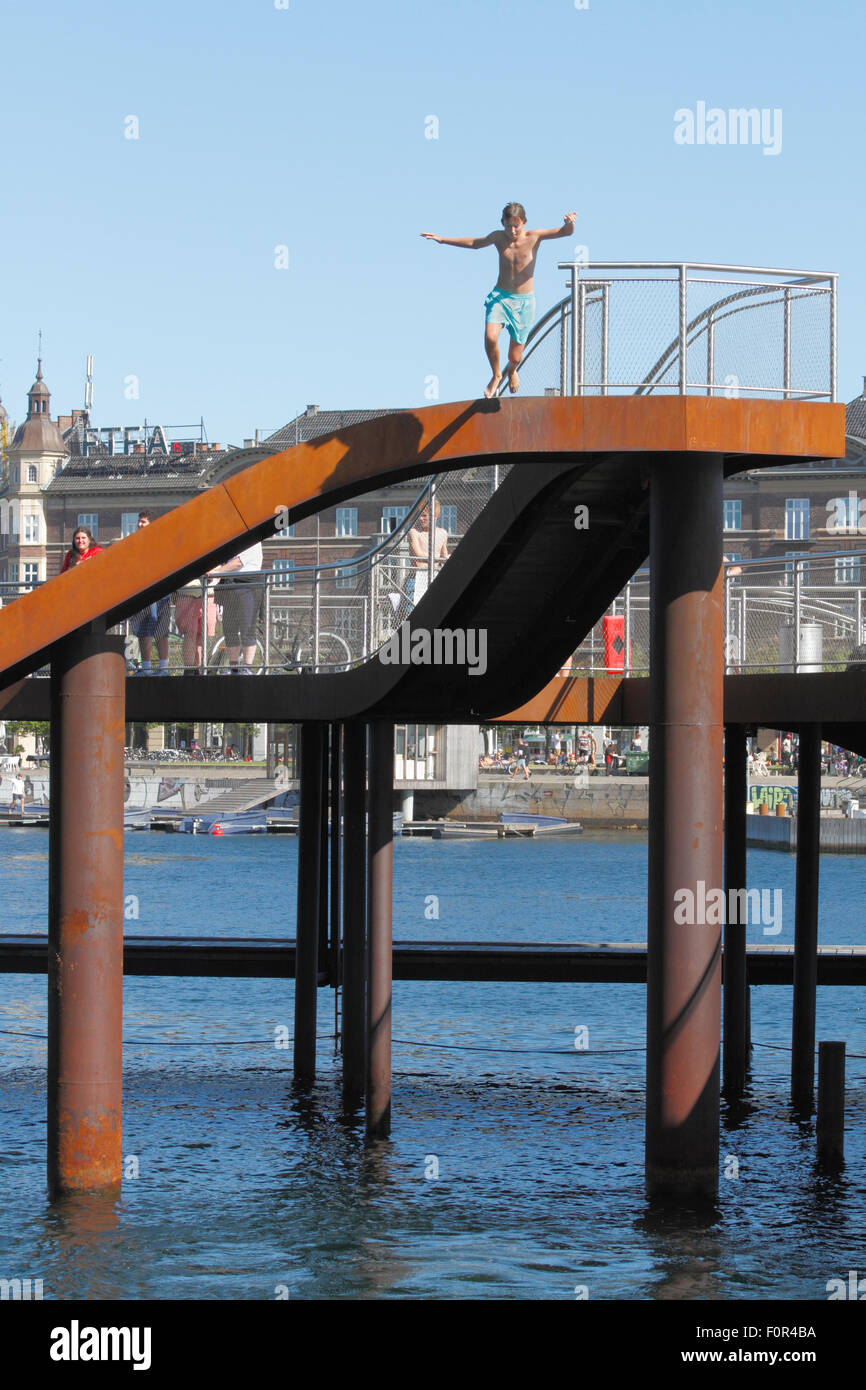 Garçon sautant du Kalvebod Bølge, des vagues de Kalvebod ou Wave, à Kalvebod Brygge, dans le port intérieur de Copenhague. Centre social, lieu pour les sports nautiques Banque D'Images