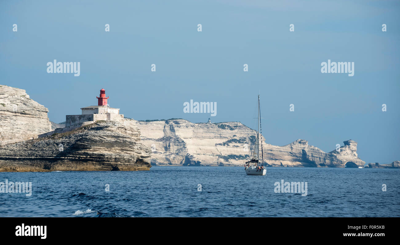 Voilier en face du phare et les falaises de craie, Bonifacio, Corse, France Banque D'Images