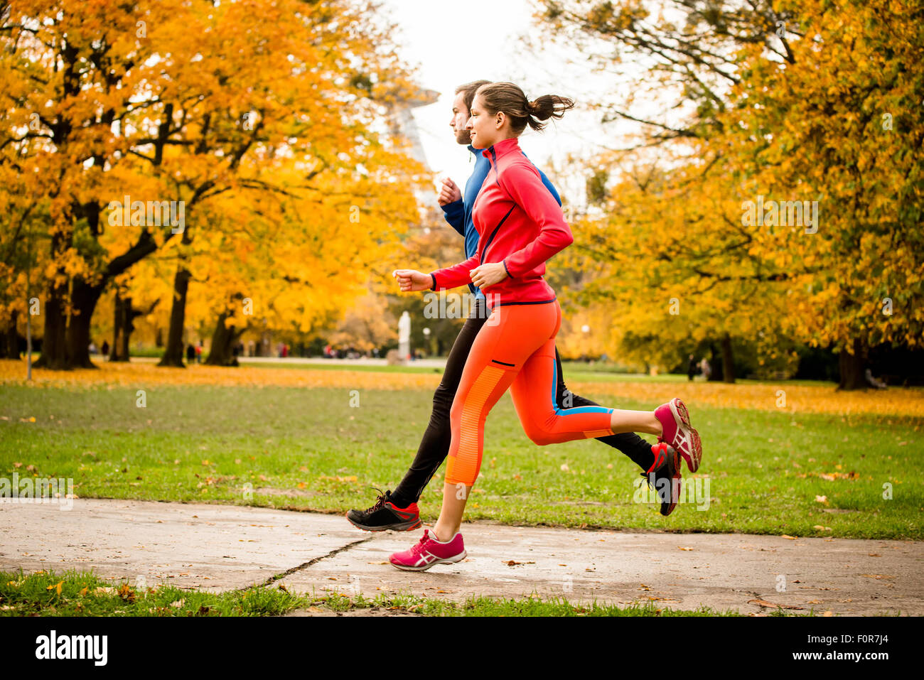 Jeune couple ensemble jogging dans le parc - vue arrière Banque D'Images