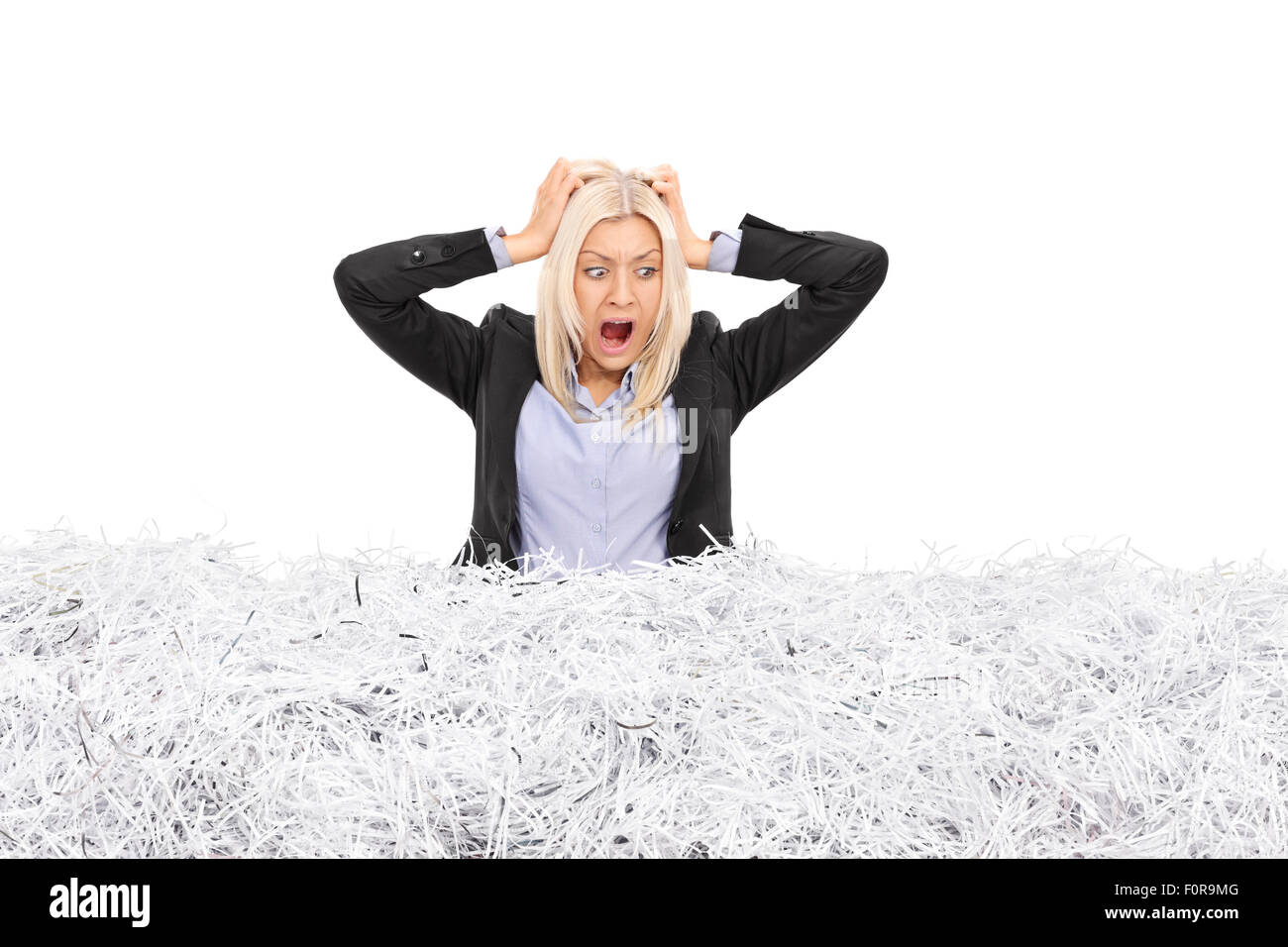 Portrait d'une jeune femme d'furieux coincé dans une pile de papier déchiqueté isolé sur fond blanc Banque D'Images