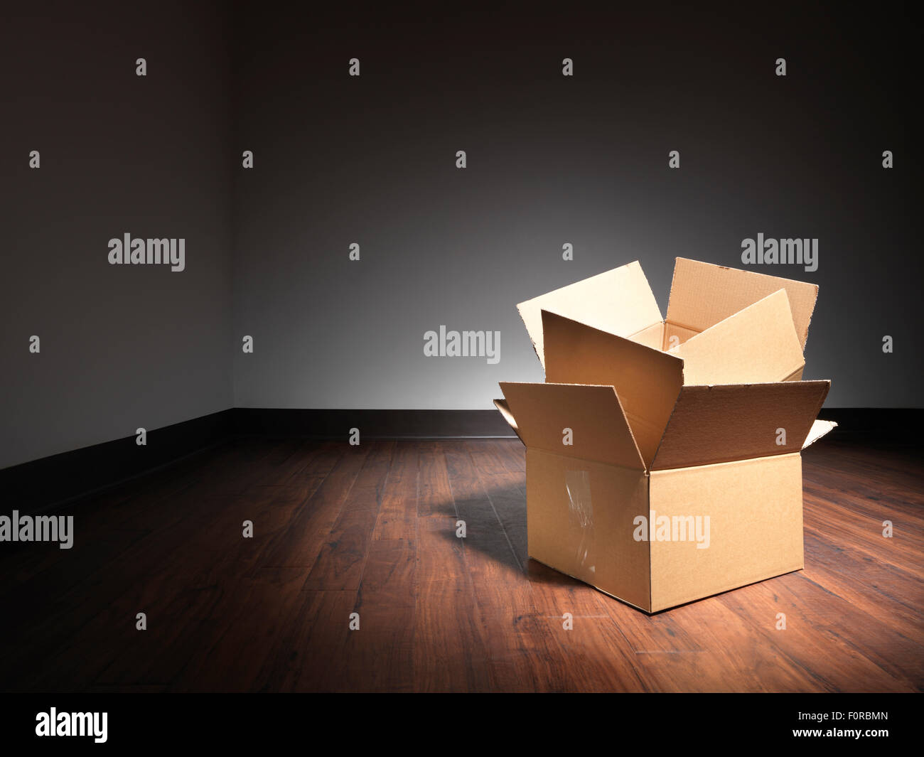 Shot de boîtes vides sur le plancher d'une salle vide lors d'un déménagement. Banque D'Images