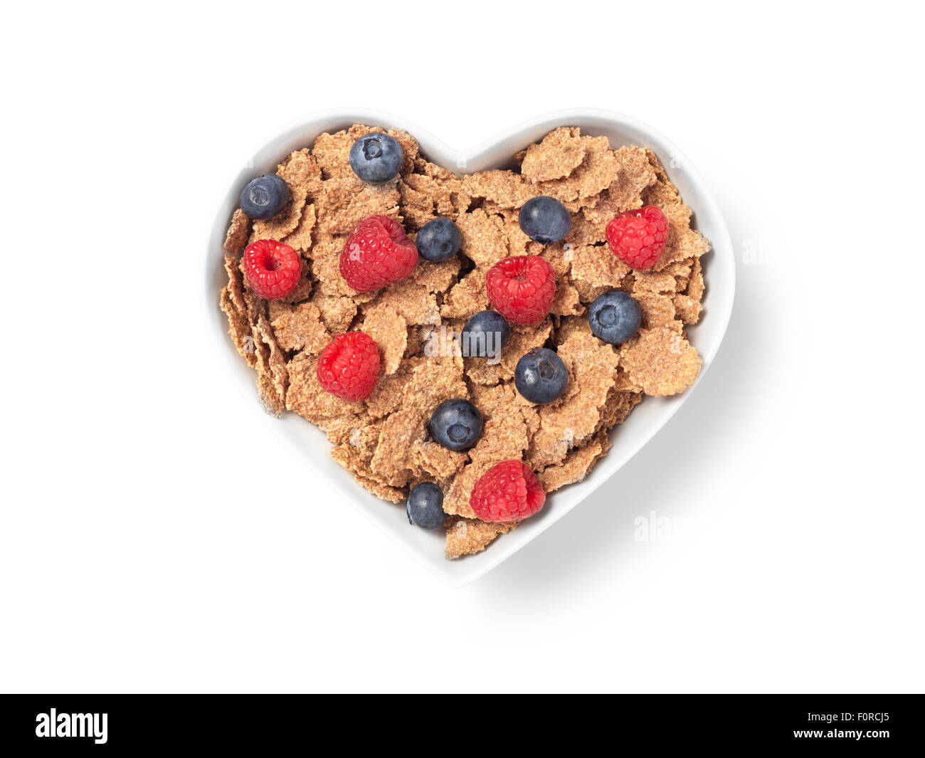 Coup de coeur un bol de céréales de son avec les framboises et les bleuets qui implique une saine alimentation et mode de vie. L'image a Banque D'Images Coup de coeur un bol de céréales de son avec les framboises et les bleuets qui implique une saine alimentation et mode de vie. L'image a Banque D'Images