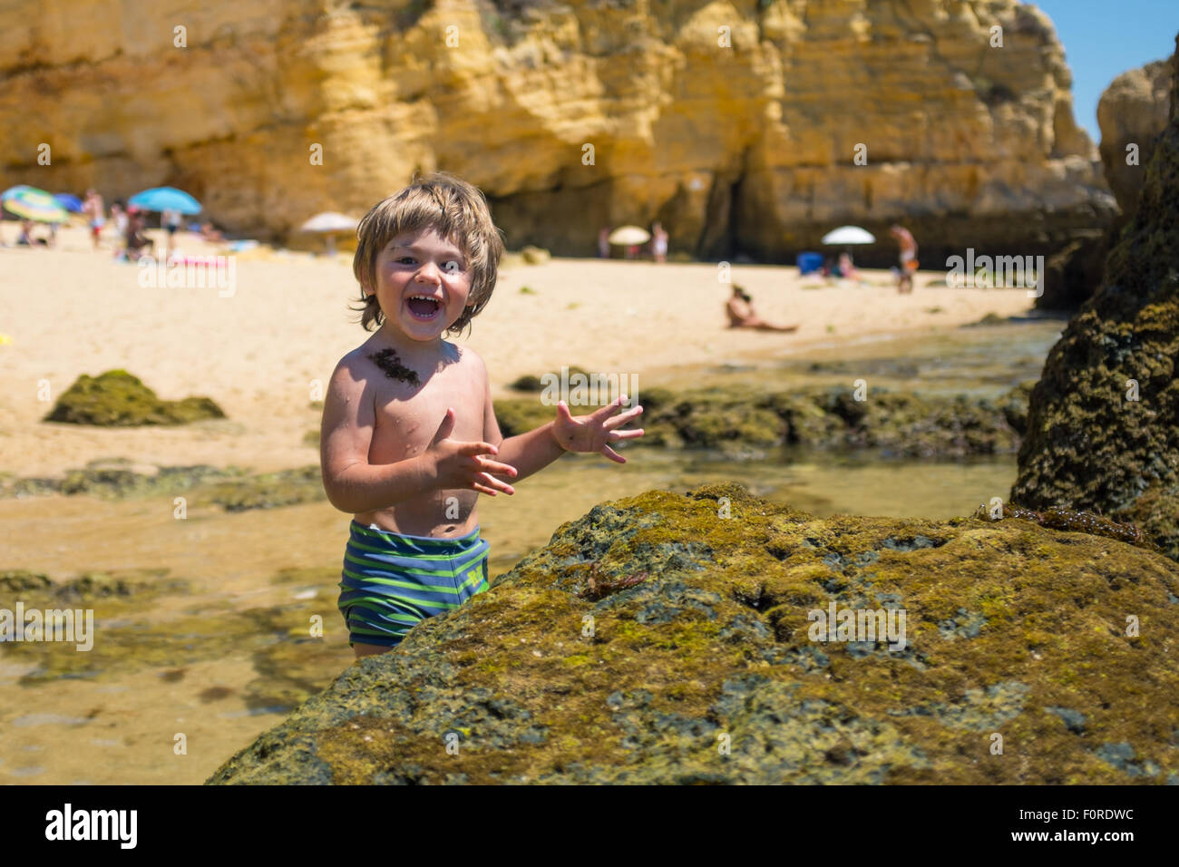 Jeune garçon s'amusant sur la plage de Sunny chaude journée. Banque D'Images