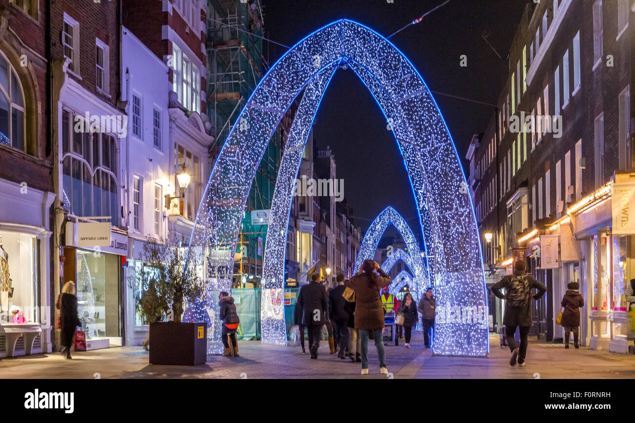 Personnes marchant le long de South Molton St à l'heure de Noël, qui a été décoré avec de grandes arches de Noël bleues, Londres, Royaume-Uni Banque D'Images