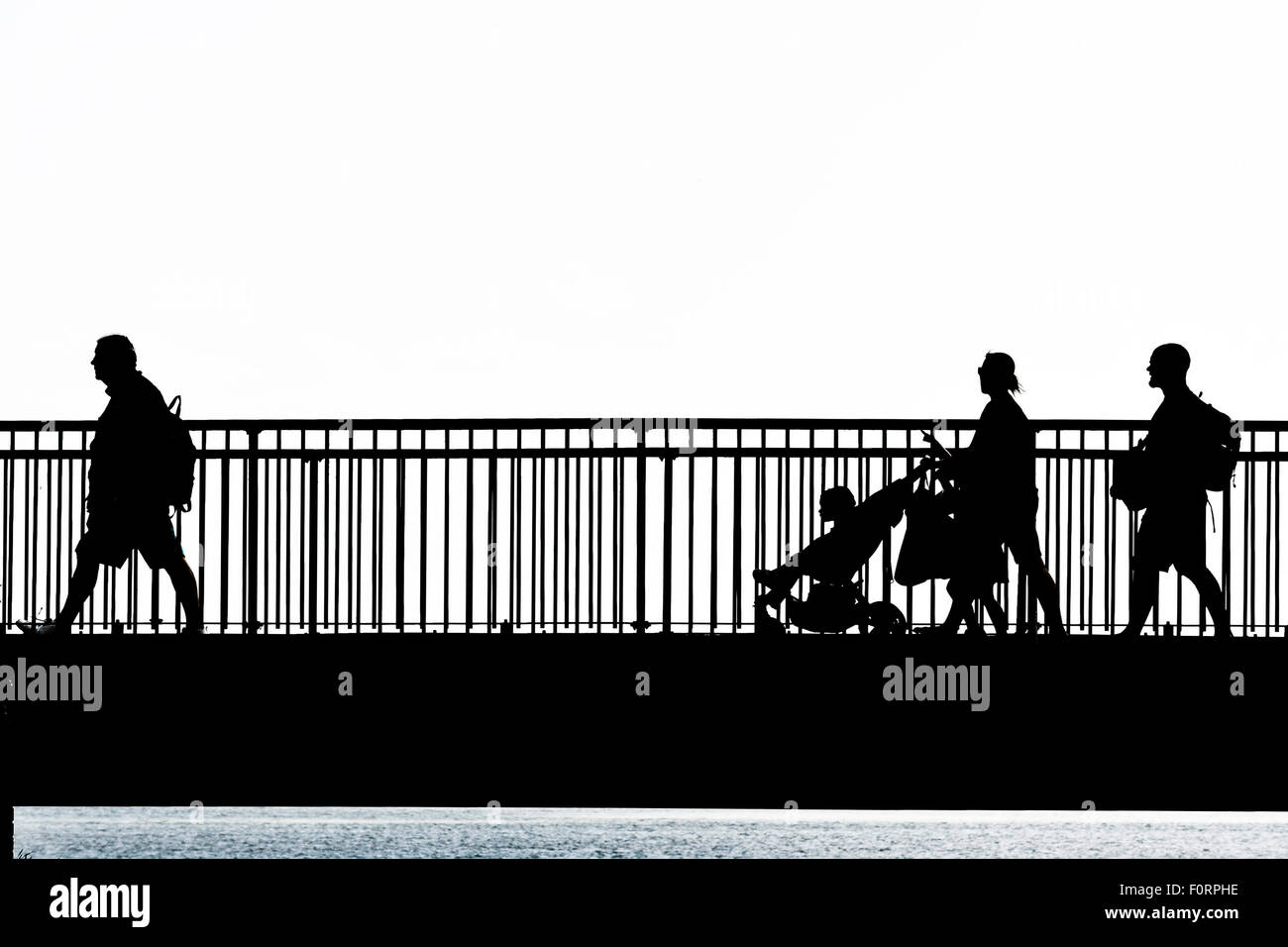La silhouette de personnes marchant sur le pont de l'écart Louisa Broadstairs, Kent. Banque D'Images