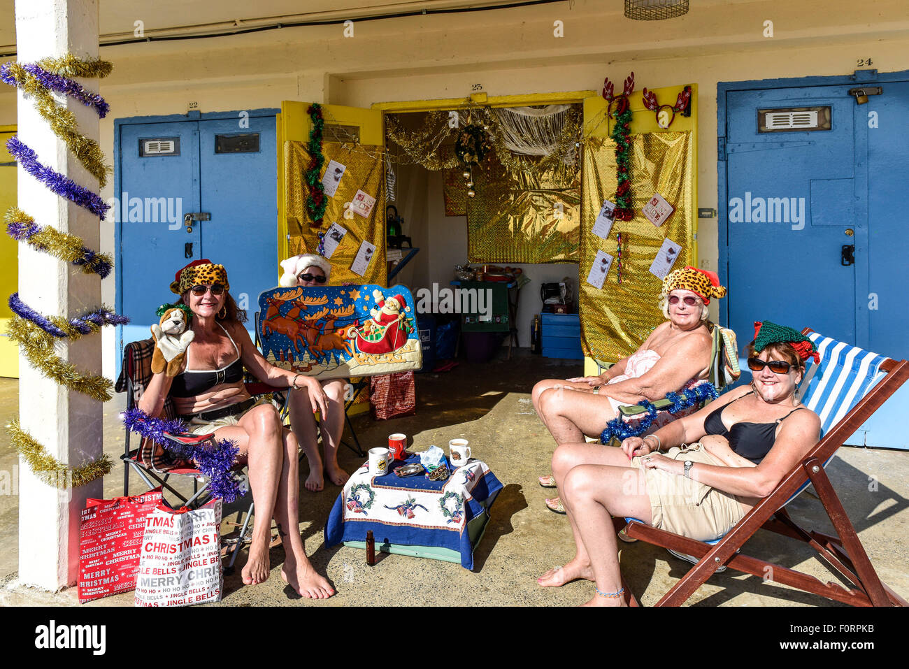 Quatre amis se détendre à leur cabane de plage décorées dans Broadstairs, Kent. Banque D'Images
