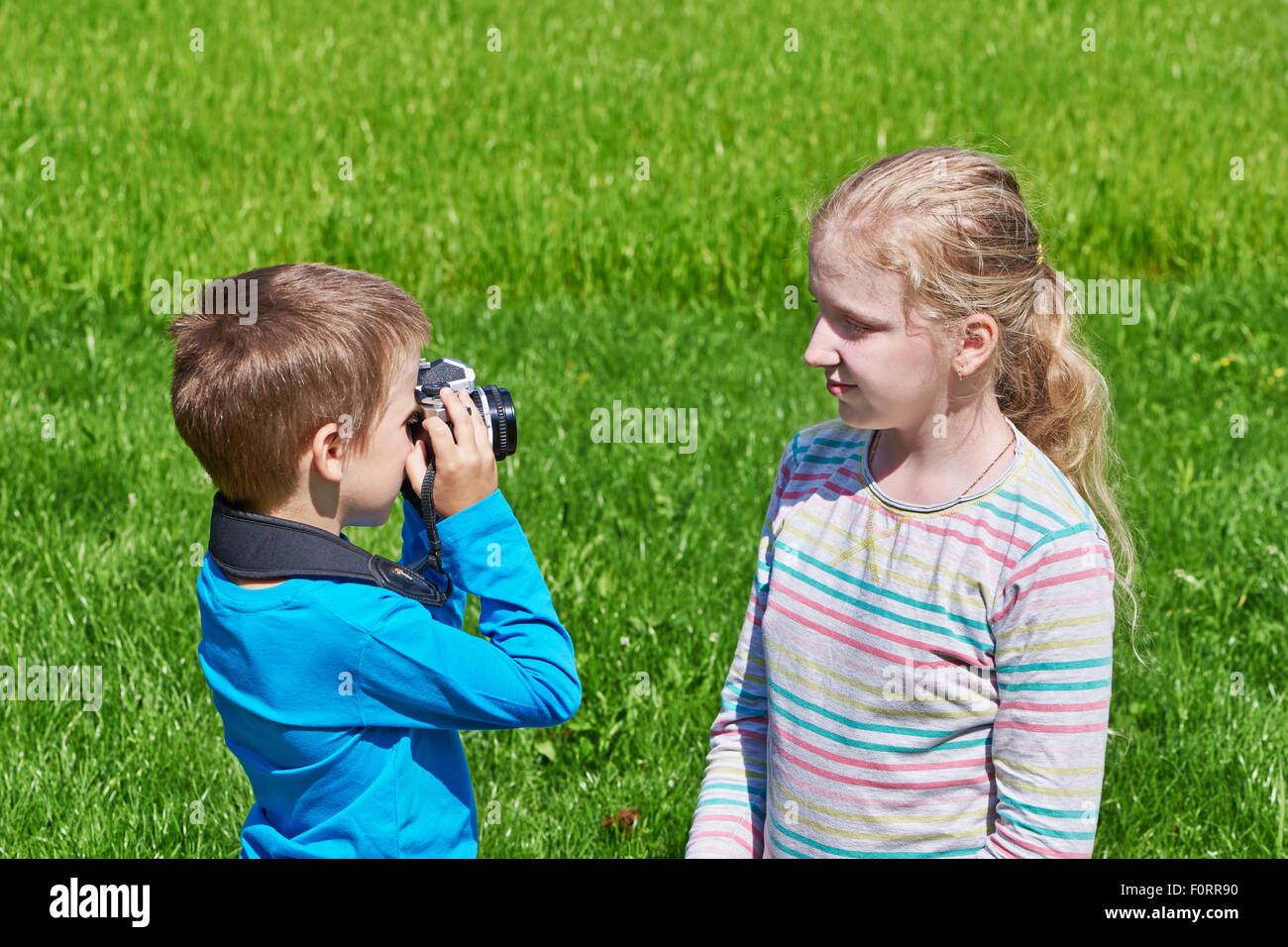 Petit garçon avec retro camera Nikon Girl tournage extérieur Banque D'Images