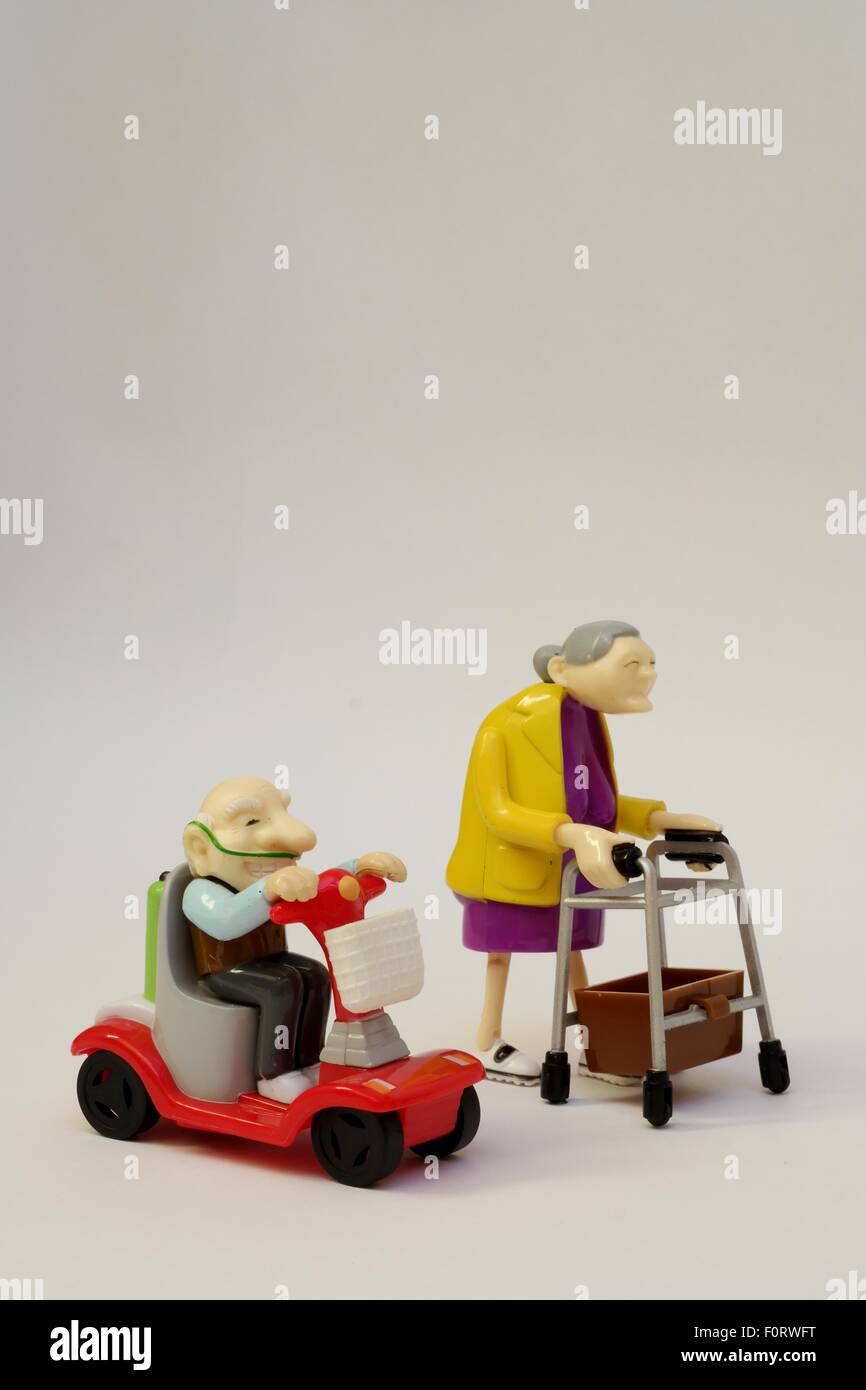 Hommes et femmes âgés toy/personnages sur fond neutre représentant course à la retraite. Toujours actif dans le grand âge. Banque D'Images
