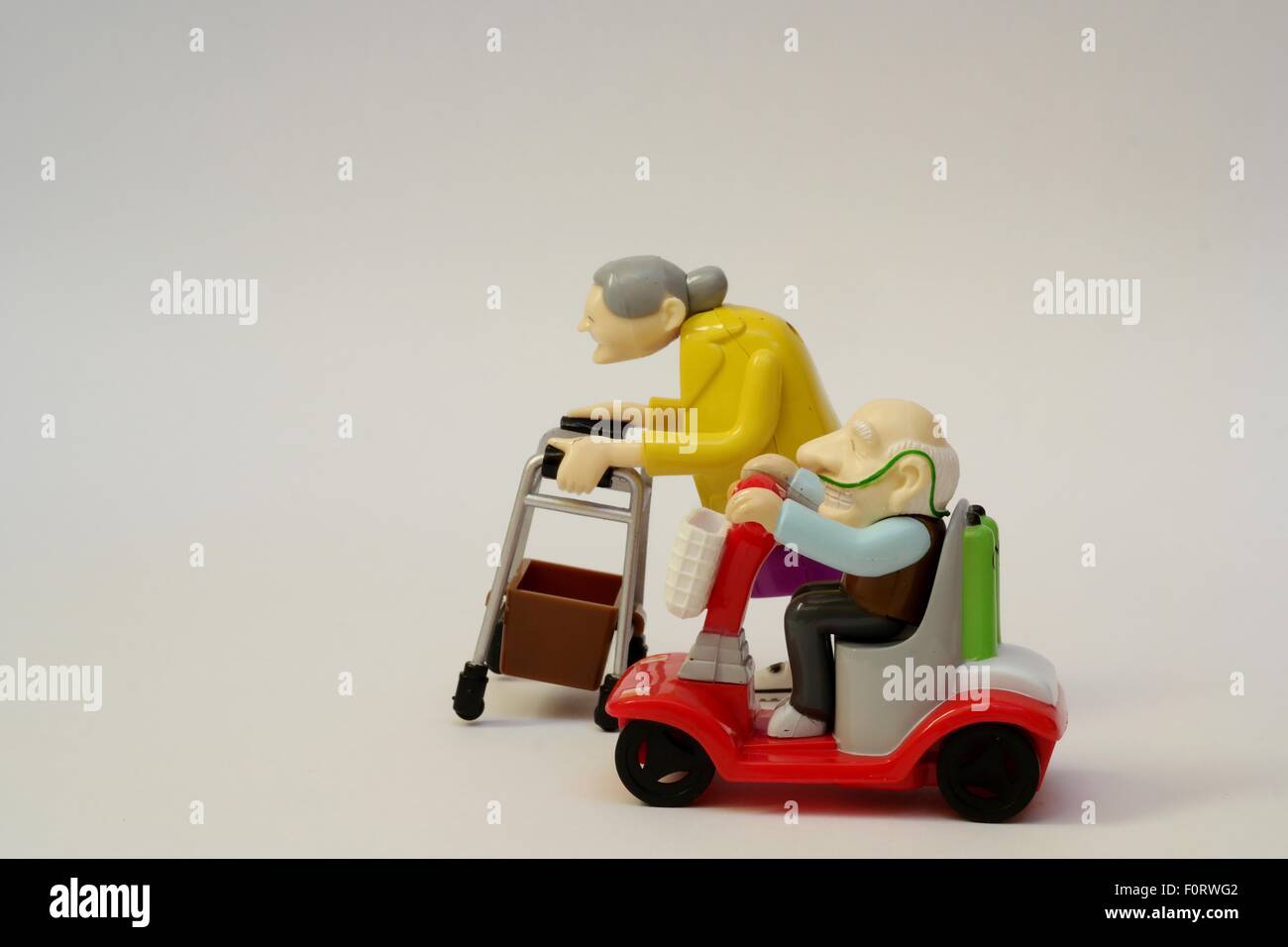 Hommes et femmes âgés toy/personnages sur fond neutre représentant course à la retraite. Toujours actif dans le grand âge. Banque D'Images