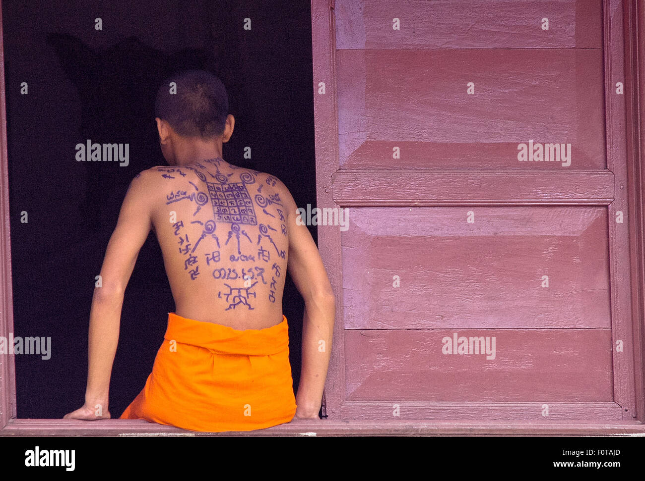 Jeune moine avec tattoo à dos en monastère à Wat Xieng Thong à Luang Prabang lao Banque D'Images