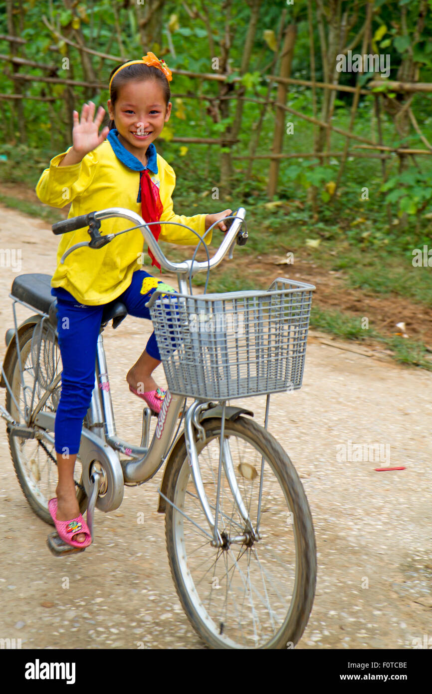 Le langage universel de randonnée à vélo - équitation fille à la maison de l'école près de Mai Chau Banque D'Images