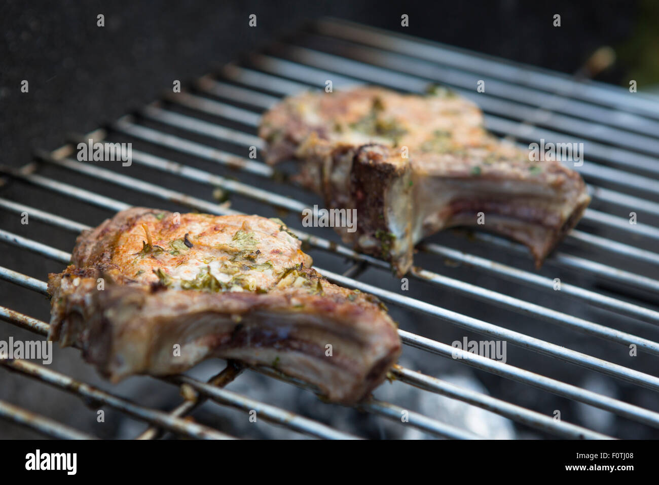 Deux escalopes de porc sur un feu de charbon de barbecue Banque D'Images