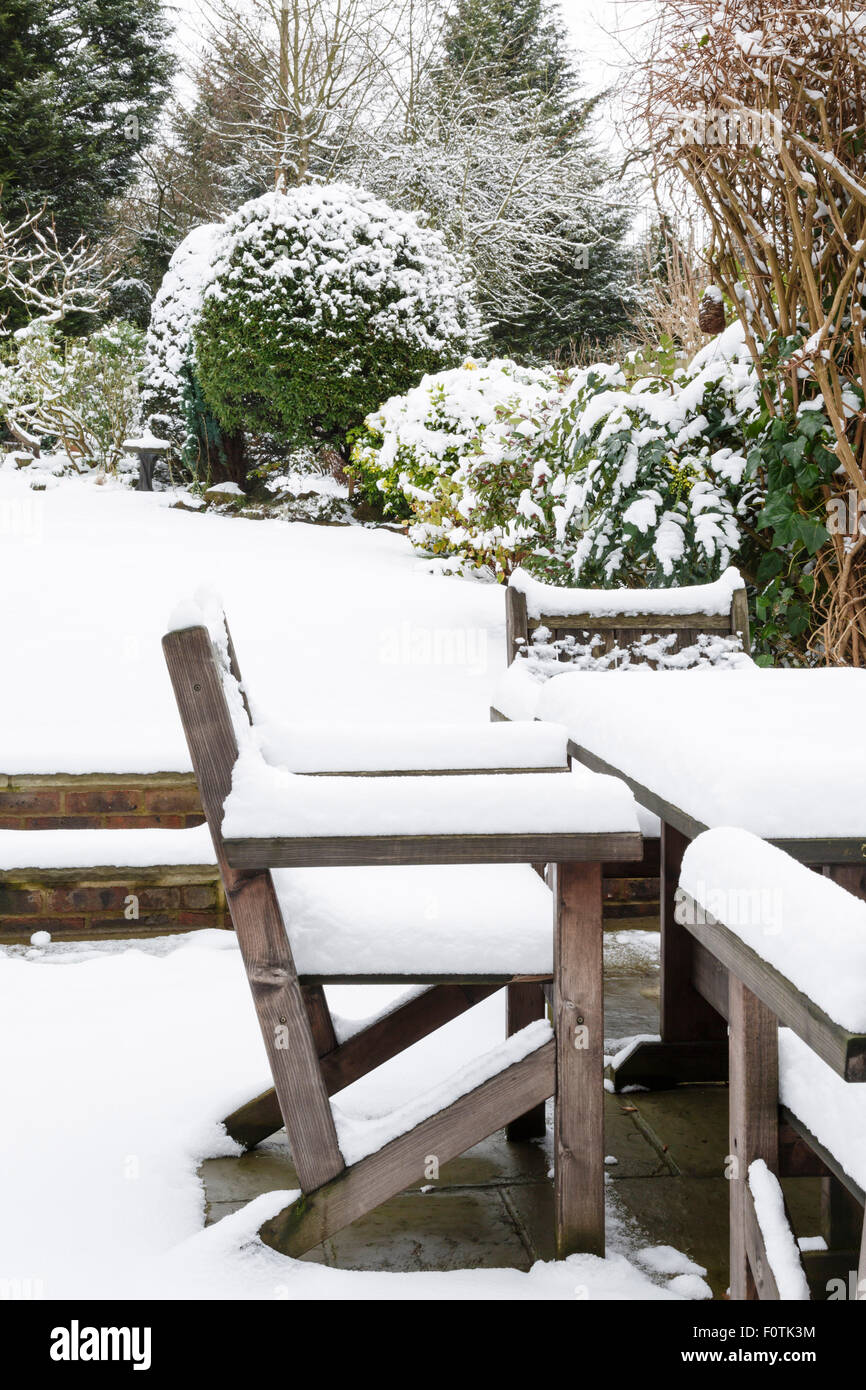 Meubles de patio couvert de neige dans un jardin en hiver Banque D'Images