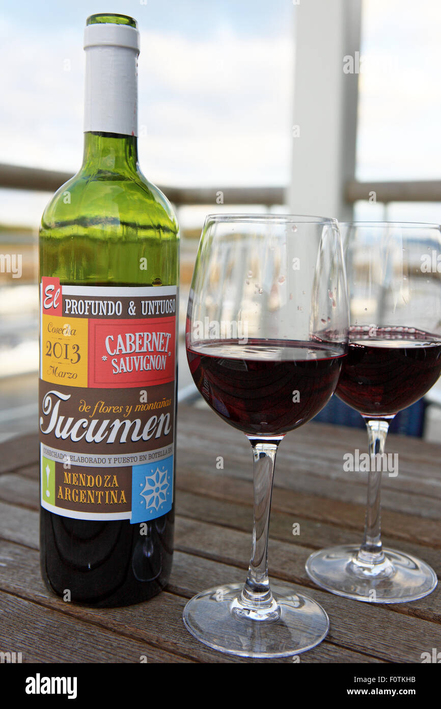 Bouteille et verres de vin rouge sur une table à l'extérieur sur un balcon par la mer Banque D'Images