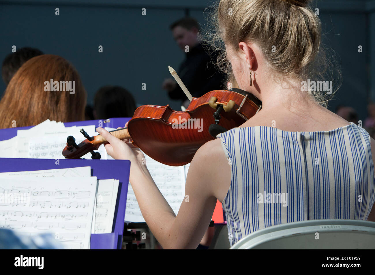 Jeune femme violoniste jouant avec le Norfolk County Youth Orchestra en concert au Forum, Norwich. Banque D'Images