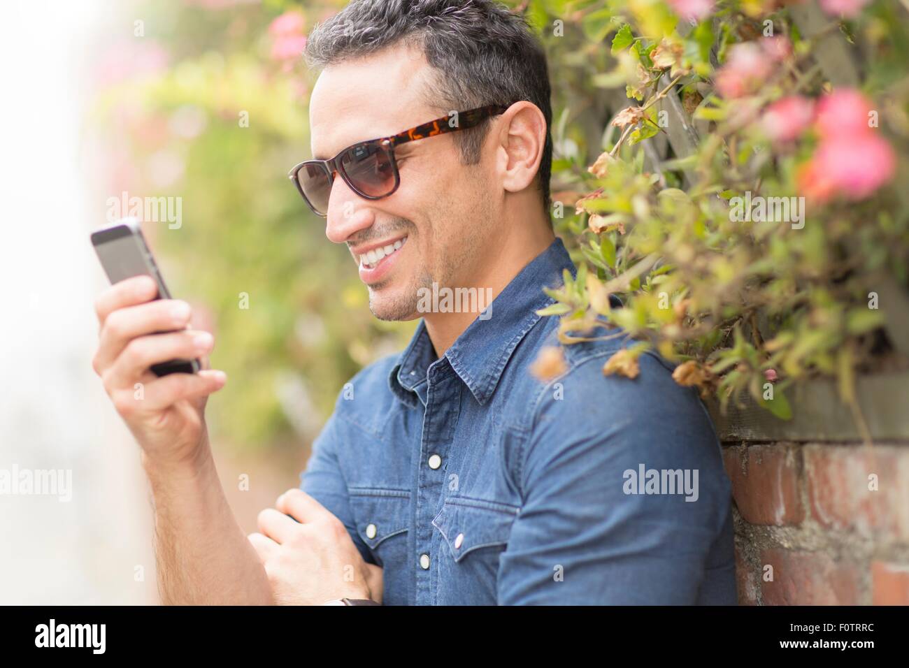 Mid adult man, à l'extérieur, à l'aide de mobile phone Banque D'Images