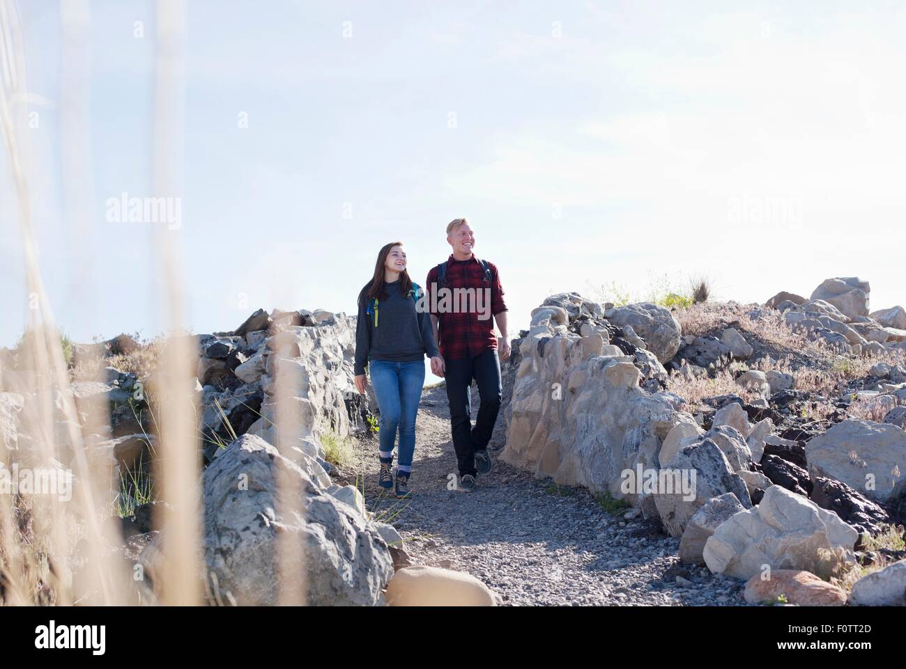Vue avant pleine longueur de young couple holding hands walking, looking away Banque D'Images Vue avant pleine longueur de young couple holding hands walking, looking away Banque D'Images