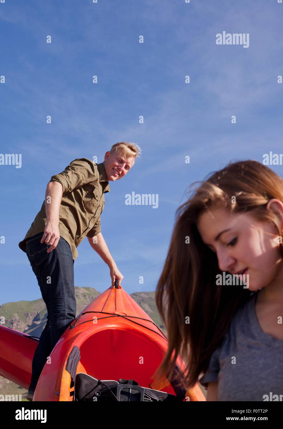 Young couple preparing kayak orange Banque D'Images Young couple preparing kayak orange Banque D'Images