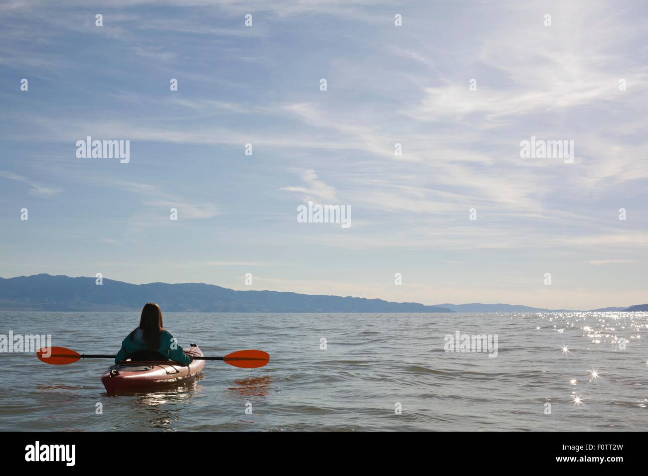Vue arrière du kayakiste jeune femme assis dans un kayak à l'eau, Grand Lac Salé, Utah, USA Banque D'Images Vue arrière du kayakiste jeune femme assis dans un kayak à l'eau, Grand Lac Salé, Utah, USA Banque D'Images
