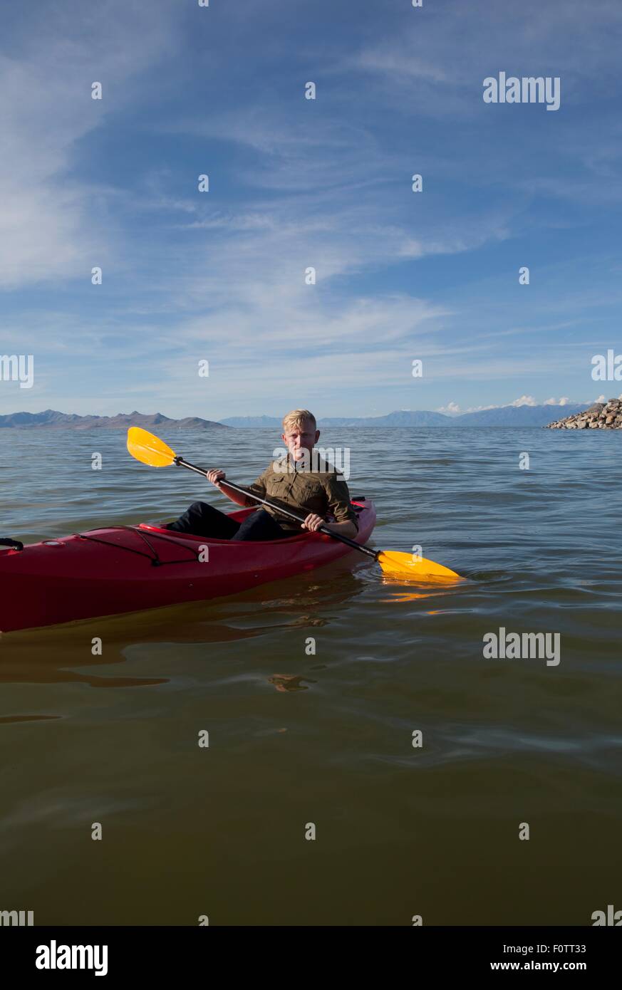 Jeune homme en tenue de kayak pagaies, looking at camera, Grand Lac Salé, Utah, USA Banque D'Images