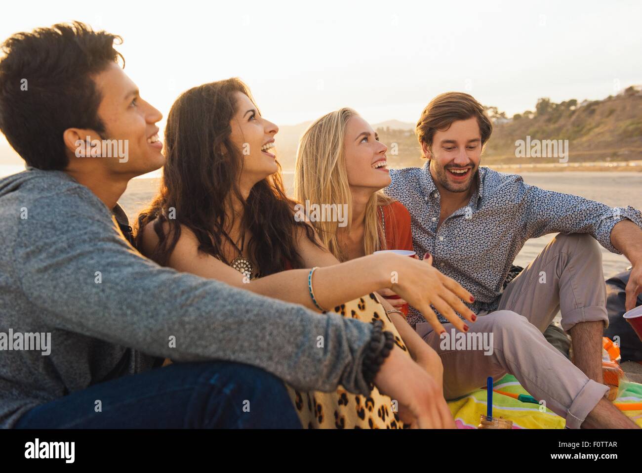 Group of friends sitting on beach Banque D'Images