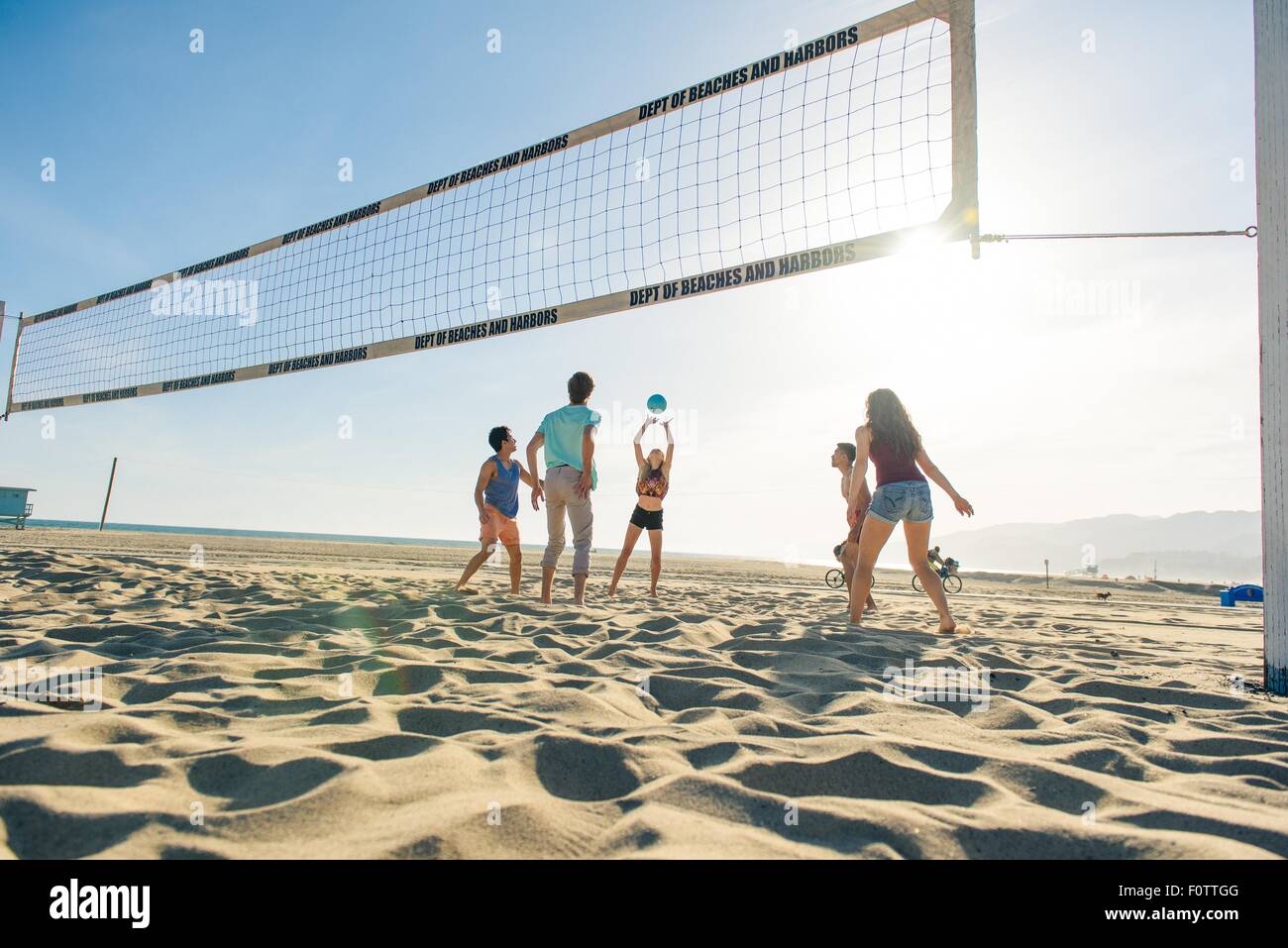 Groupe d'amis jouer au volley-ball sur plage Banque D'Images