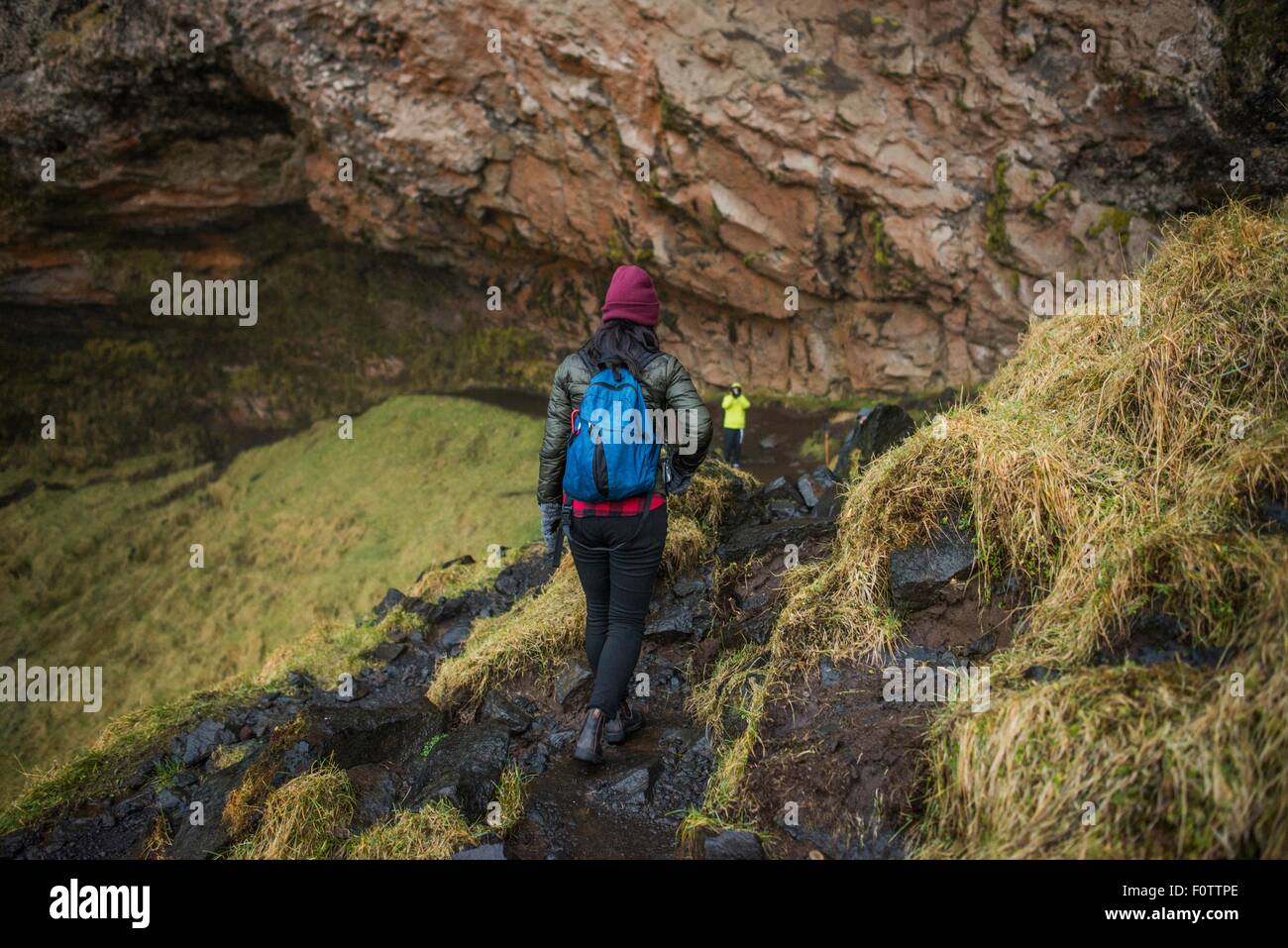 Deux touristes descendant en cascade de Seljalandsfoss, chemin d'Islande Banque D'Images
