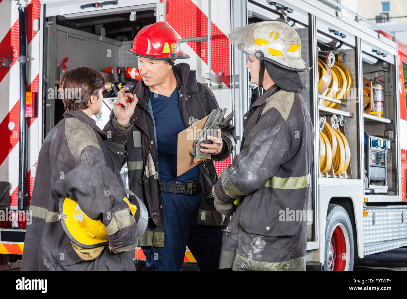 Discuter avec des collègues pompiers camion contre Banque D'Images