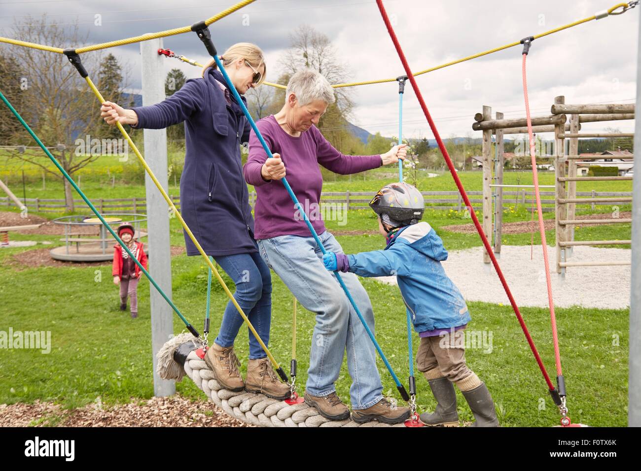 Trois génération de la famille jouant sur le pont de corde Banque D'Images