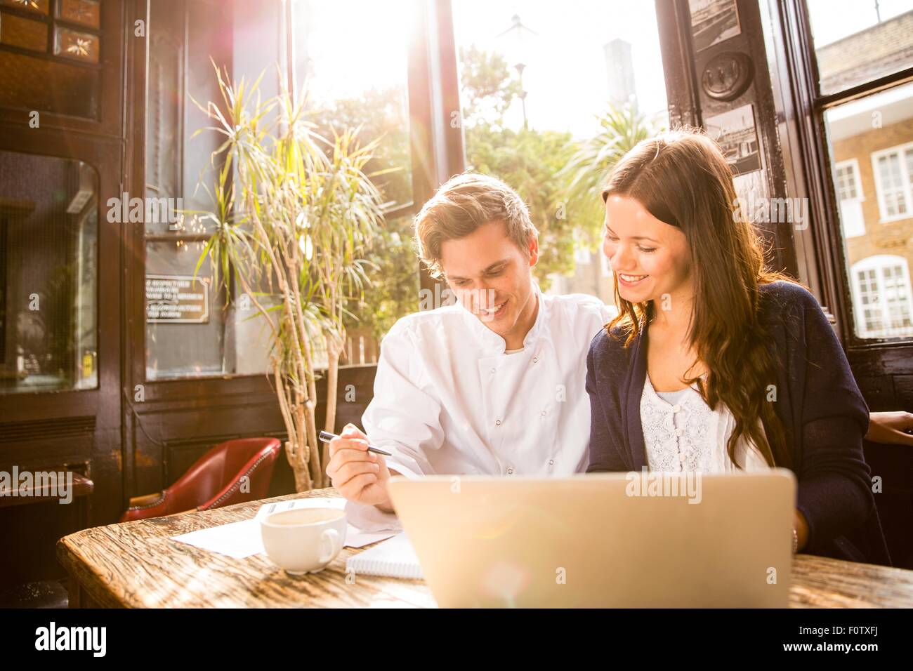 Couple au travail en bar with laptop Banque D'Images