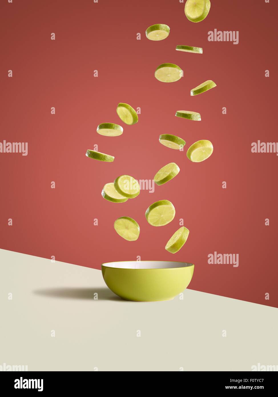 Tranches de citrons frais tomber dans la cuvette jaune Banque D'Images